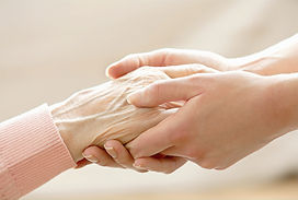 A young person and an elderly person hold hands, a symbol of intergenerational connection.