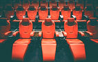 A photo of comfortable red reclining seats in a nearly empty movie theater.