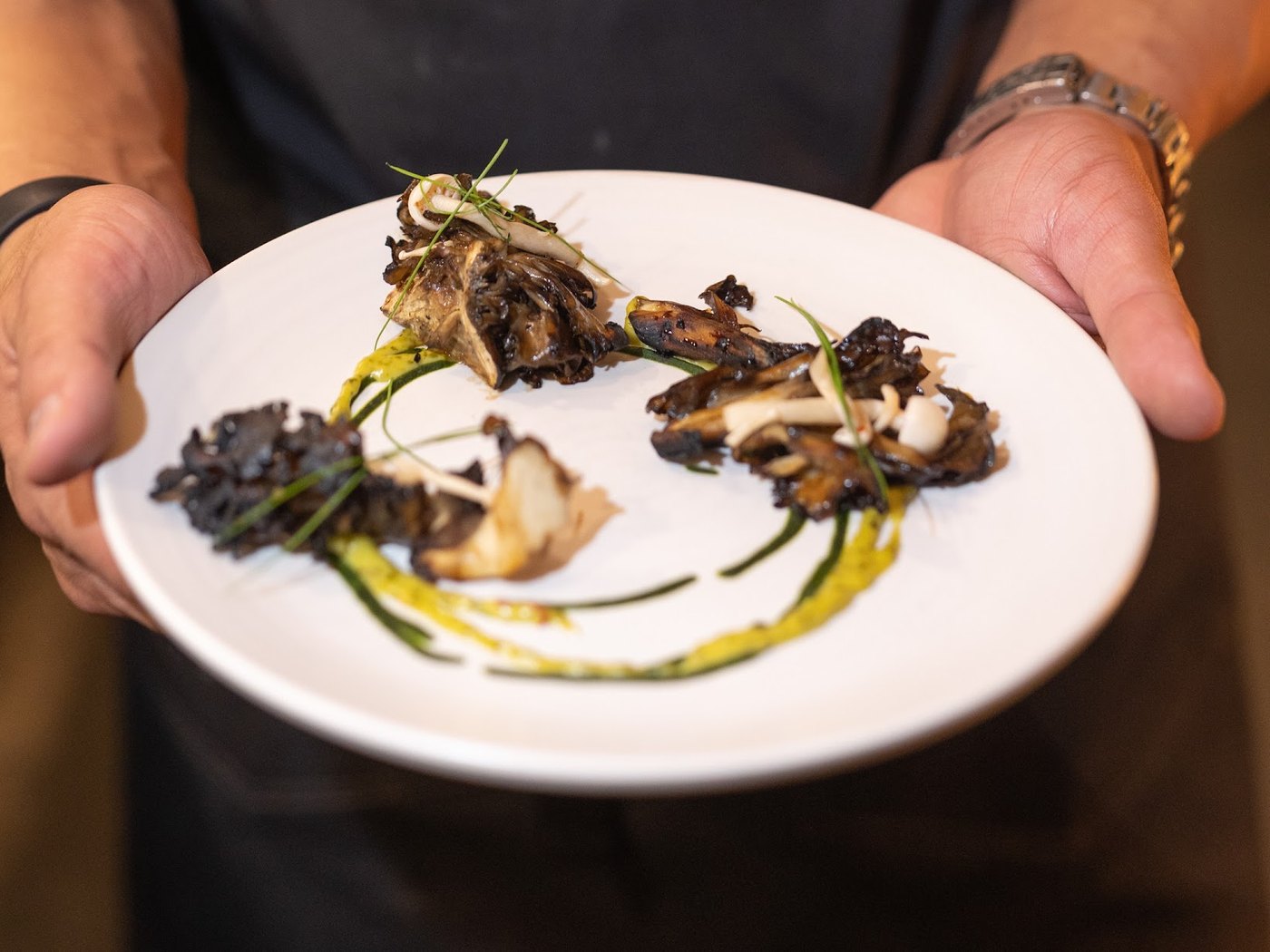 A chef presenting a plated course at the sponsored supper