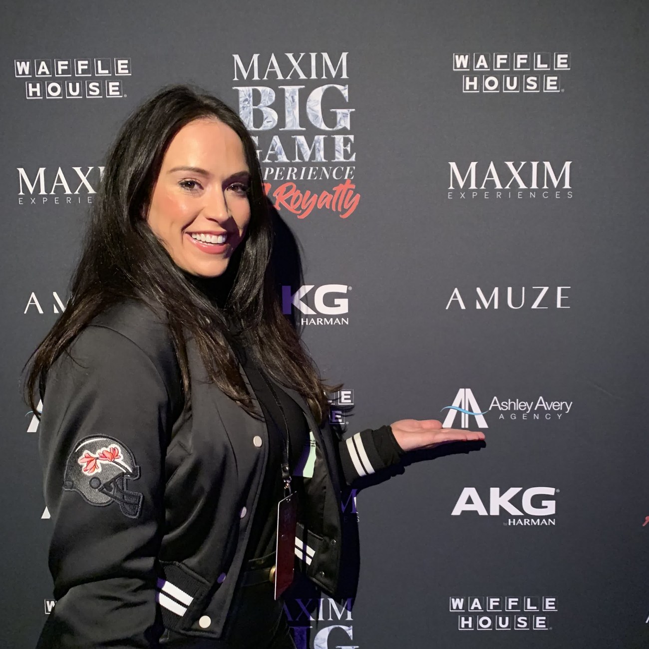Ashley Blalock beside the Maxim Big Game Experience partner board, with the Ashley Avery Agency logo among the event partners, Atlanta, February 2019
