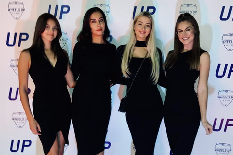 VIP hosts in matching black dress code at a client step-and-repeat