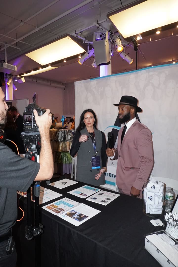 A production crew filming an interview at the Ashley Avery Agency booth