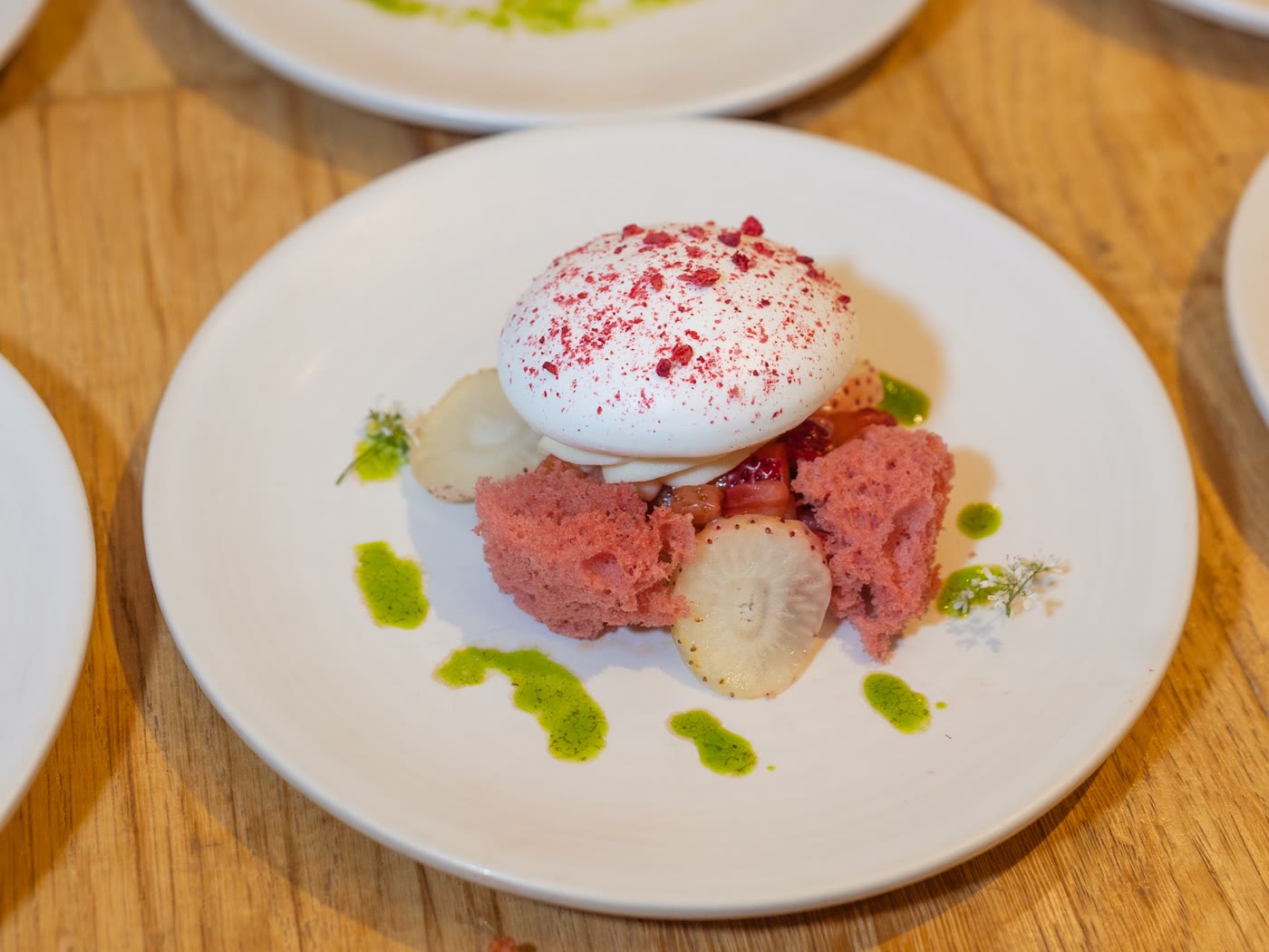 A plated dessert course ready for service at the cover party, the rest of the row set out behind it