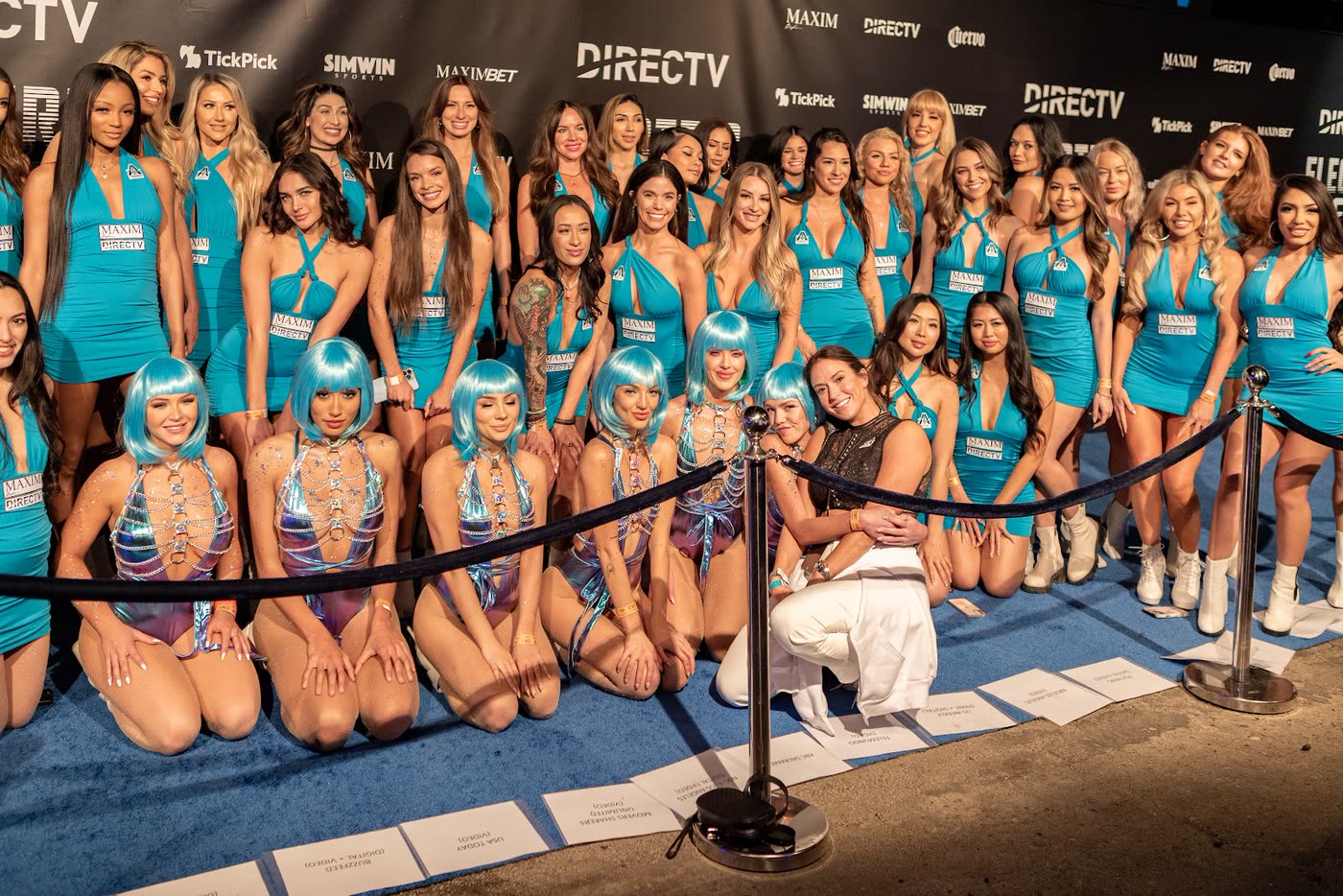 The Ashley Avery Agency hospitality team in matched teal uniforms with the founder on the sponsor carpet at the MAXIM Big Game experience