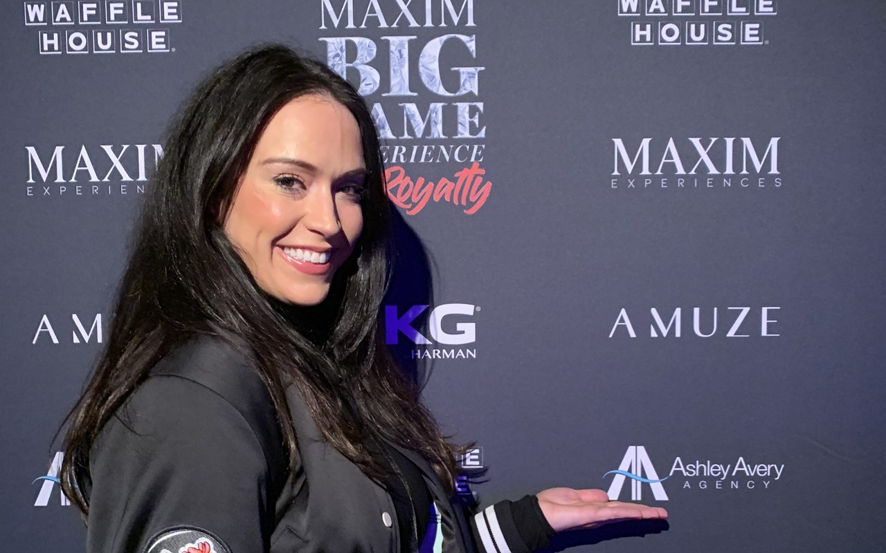 Ashley Blalock beside the Ashley Avery Agency logo on the Maxim Big Game Experience sponsor wall at ATL Royalty, Atlanta, February 2019