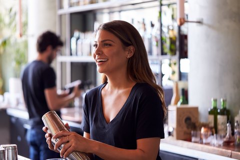 A bartender mixing a drink behind the bar
