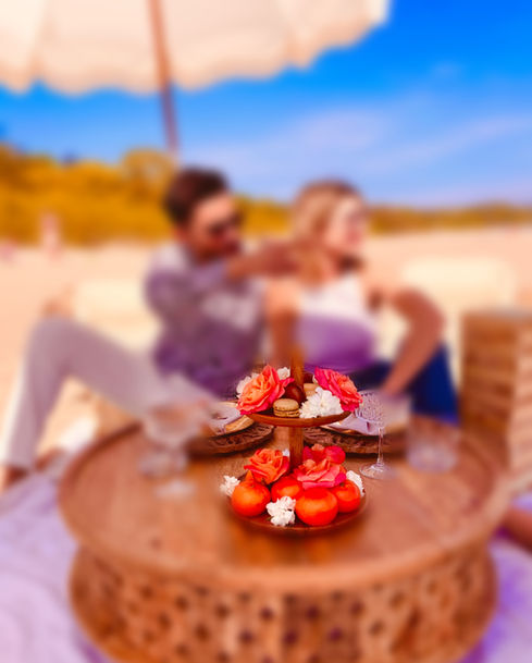 Piknik na plaży pod parasolem z paterą z owocami. Romantyczna randka na plaży.