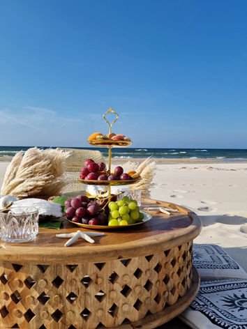 Okrągły stół premium z drzewa mango. Egzotyka w plenerze. Piknik na plaży w Trójmieście. Elegancja łączy się z naturą tworząc klimat komfortu i luksusu. wygodne poduchy, piękna zastawa, ciepła plaża i błękitne niebo nad głową. Raj na ziemi w najlepszym wydaniu