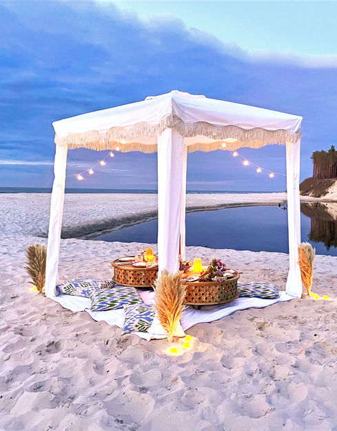 Luksusowy piknik na plaży pod baldachimem w stylu boho. Czas spędzony z bliskimi na idealnym pikniku na plaży.