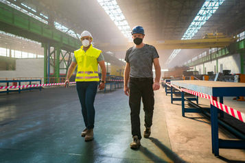 Photo de deux techniciens qui marche et inspectent la ligne de production