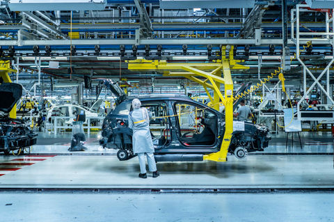Photo professionnelle d'une technicienne travaillant dans une usine de production automobile