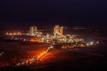 Site industriel éclairé de nuit, photographie industrielle au Maroc (Casablanca), rendu premium 2026.