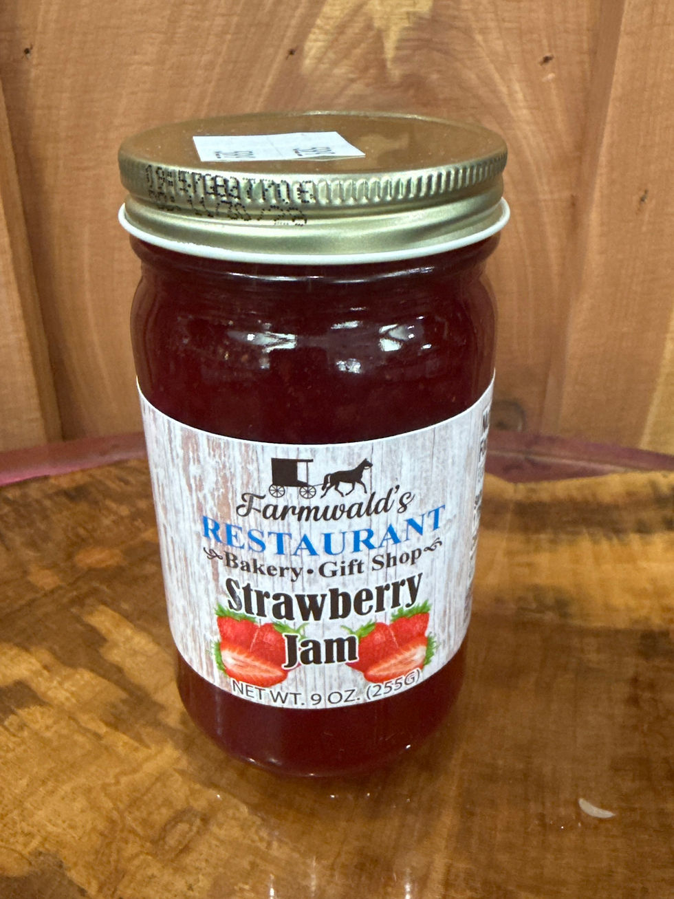Farmwald's Strawberry Jam 9oz jar on a wooden surface