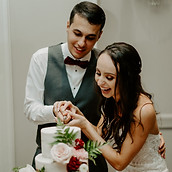 a bride and groom cut their wedding cake with cake flowers