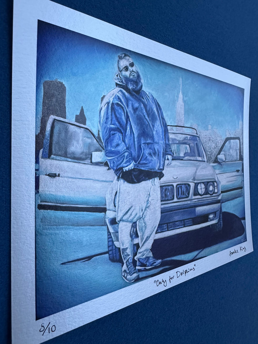 Thumbnail: Drawing of bearded man in blue hoodie with car, city background