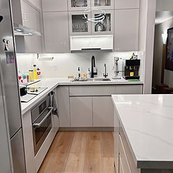 Condo kitchen renovated by Reno Rabbit with grey cabinetry and wood flooring