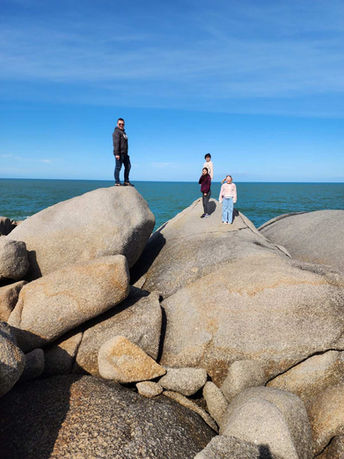 4 people climbing over the rocks at Boomer beach, Port Elliot, Fleurieu Peninsula Tour