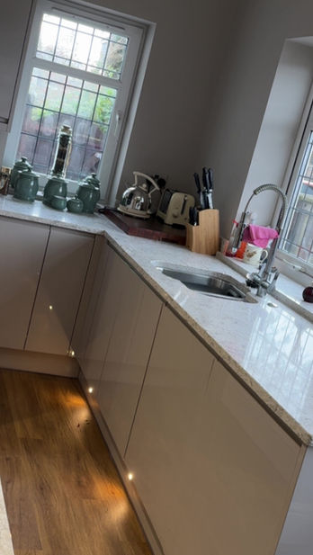 Modern kitchen with light cabinets and two windows