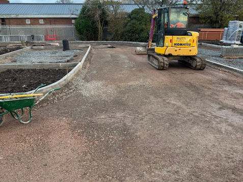 Small yellow excavator on a gravel construction site