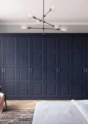 Elegantly styled bedroom featuring a floor-to-ceiling dark blue panelled wardrobe