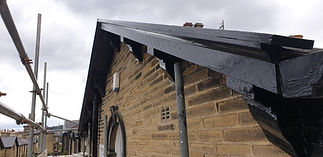 Workers installing a new roof on a commercial building under clear blue skies