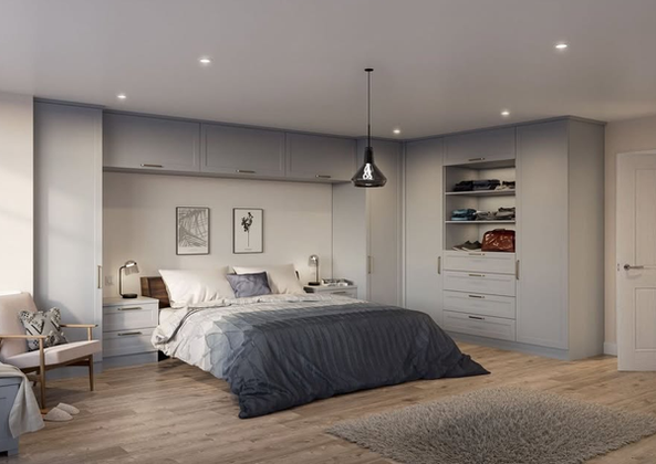 Spacious bedroom with built-in grey wardrobes, shelving, and overhead bridge storage around the bed