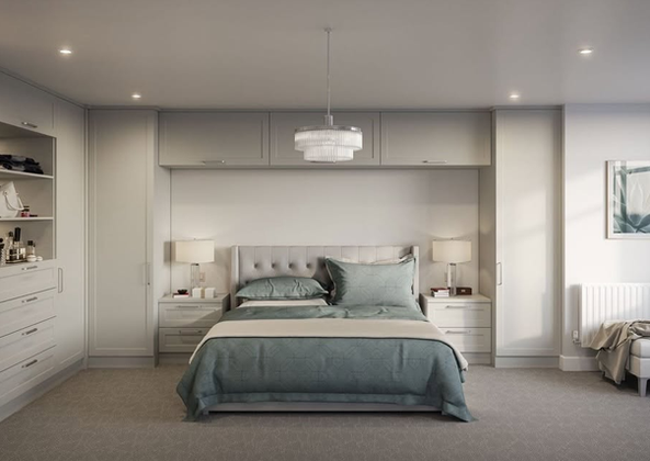 Minimalist bedroom featuring a grey bed frame and built-in overhead storage cabinets