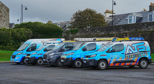 Line of ATS Electrics branded blue service vans parked outdoors