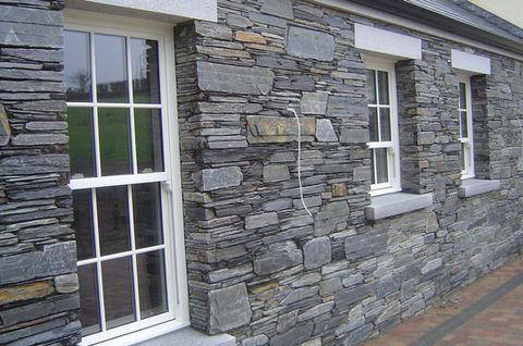 stone cladded house with white framed windows