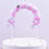 Thumbnail: A cake topper featuring a pink arch of small balloons with ribbons.