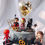 Thumbnail: A cake decorated with chibi-style superhero figurines, a balloon, and pretzels.