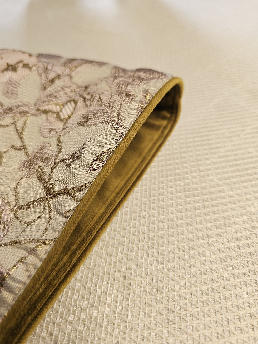 Thumbnail: Close-up of embroidered fabric with gold piping