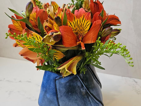 Burnt orange flowers placed in a blue navy vase