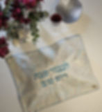 Challah cover with 'In honor of Shabbat and Yom Tov' text, wine, and flowers