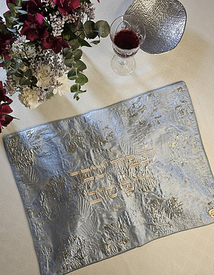 Shimmering challah cover with Hebrew text, wine, flowers