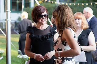 Image of partygoers mingling outside.
