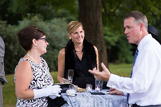 Image of three partygoers mingling outside at the Mad Men gala.