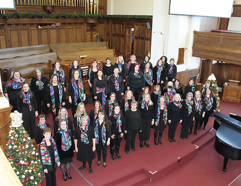 Choir is standing together and looking up at the photographer