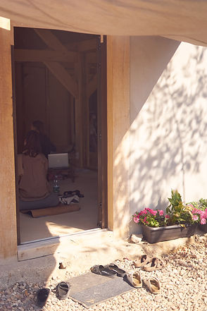 Students in the indoor yoga space, looking through the door