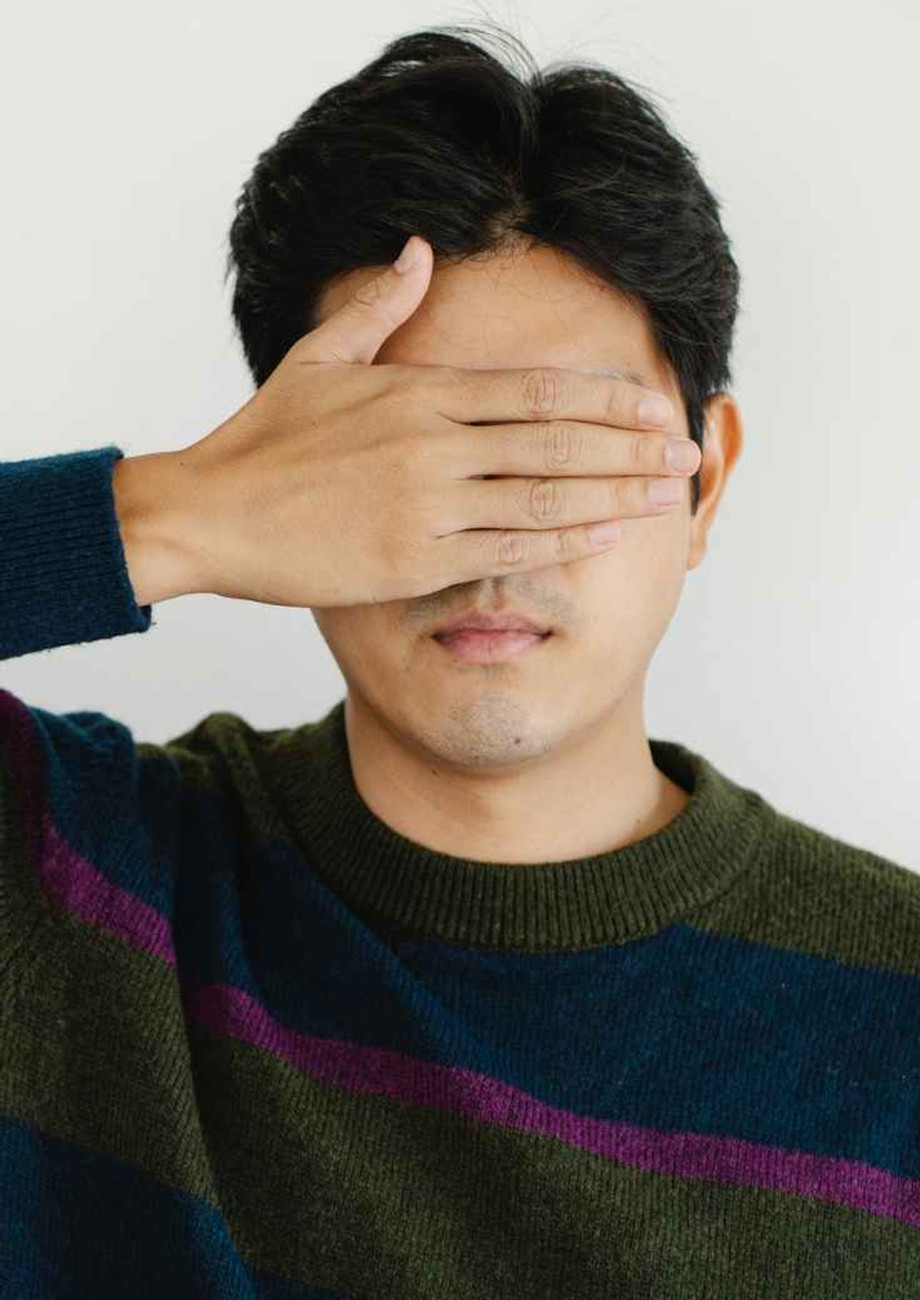 photo of man covering his eyes