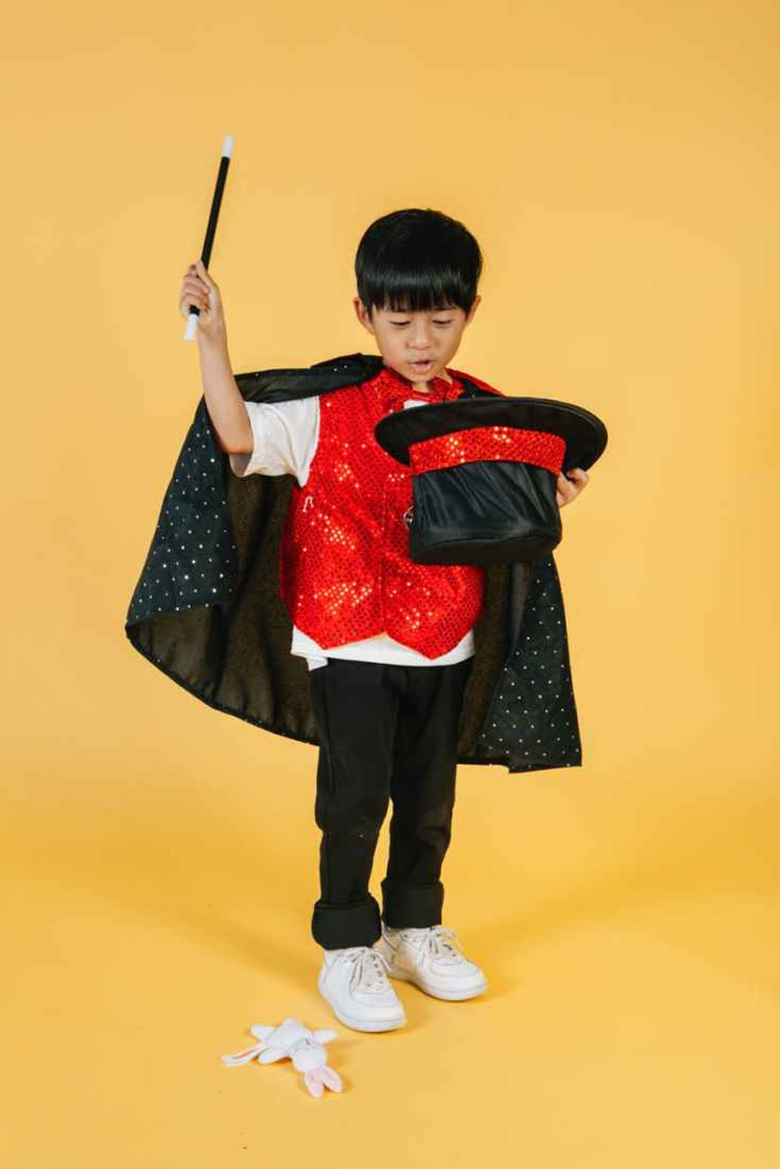 asian kid in studio wearing magician costume