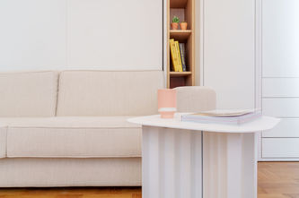 Détail du canapé blanc et de la table basse dans un séjour aux tons clairs