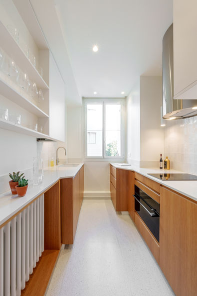Petite cuisine blanche et bois avec rangements sur mesure, plan de travail clair et électroménager intégré