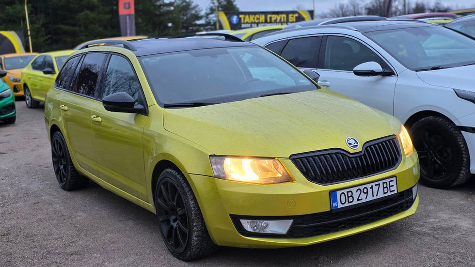 Skoda Octavia Combi в зелен цвят, налична в автокъща Такси Груп БГ в България, проверен употребяван комби автомобил, подреден сред други автомобили, подходящ за такси или семейно ползване