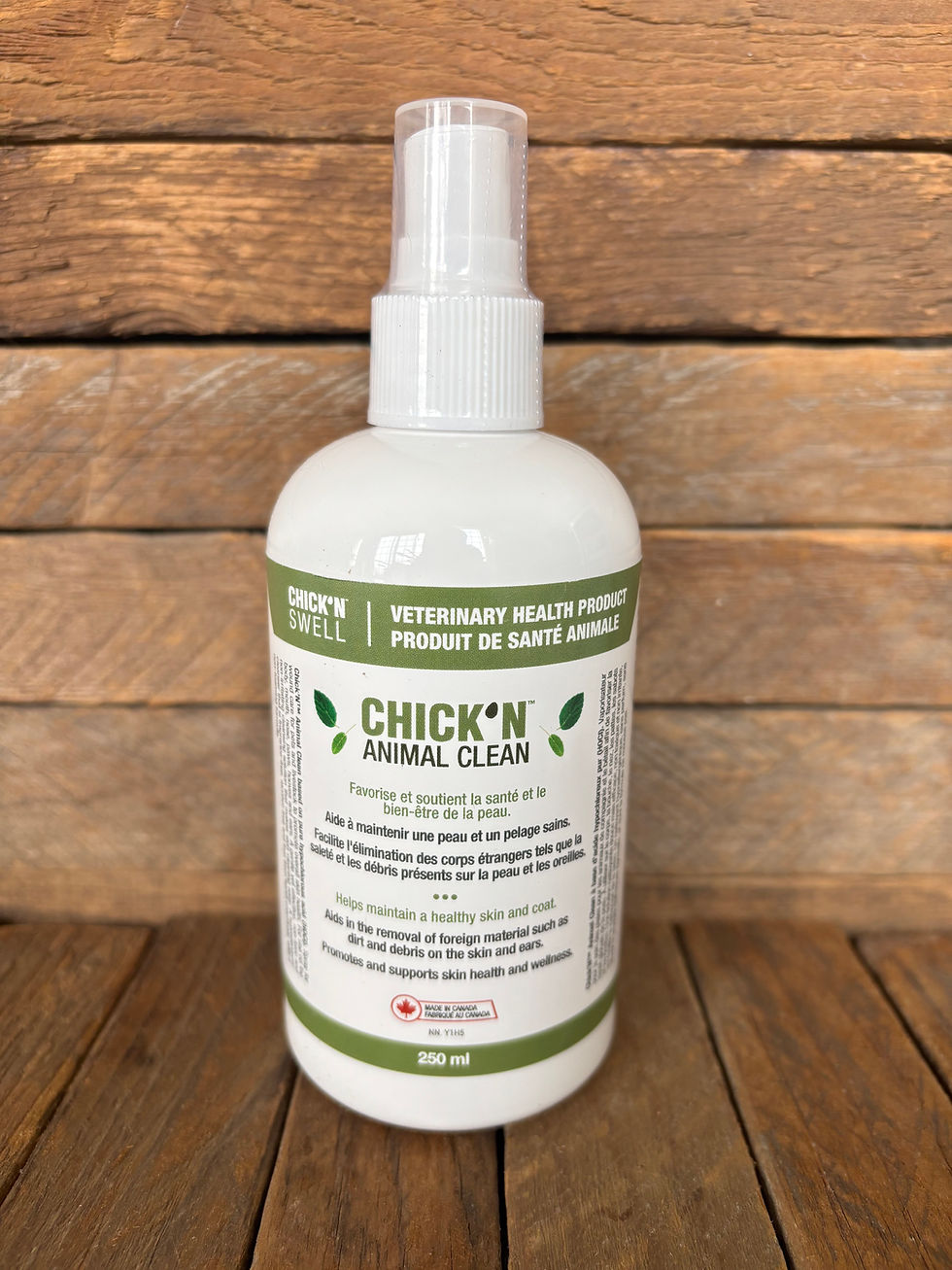 A 250ml spray bottle of a wound cleaning product in front of a wooden wall.