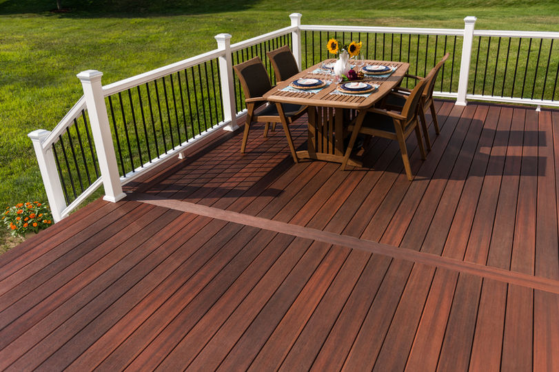 A deck with steel framing, cinnabar composite and Trex white composite railings with black balusters.