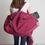Thumbnail: Big maroon and grey bag on should of model full of yoga equipment
