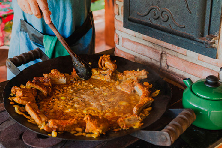Imagem de uma pessoa mexendo comida em panela.