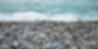 Rounded pebbles and stones on a beach.