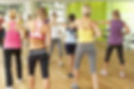 women with dumb bells in a fitness training class
